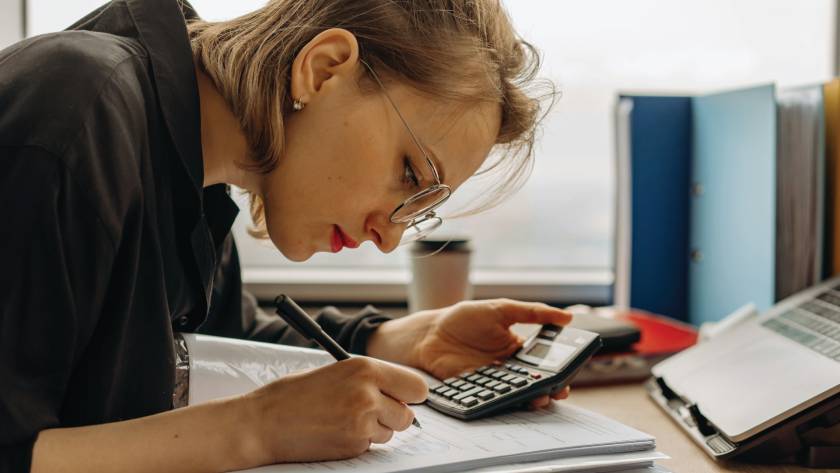 Women working on tax documents while holding a calculator.