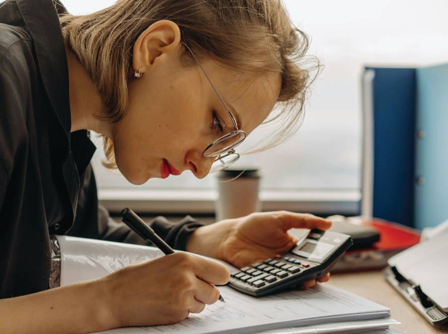 Women working on tax documents while holding a calculator.