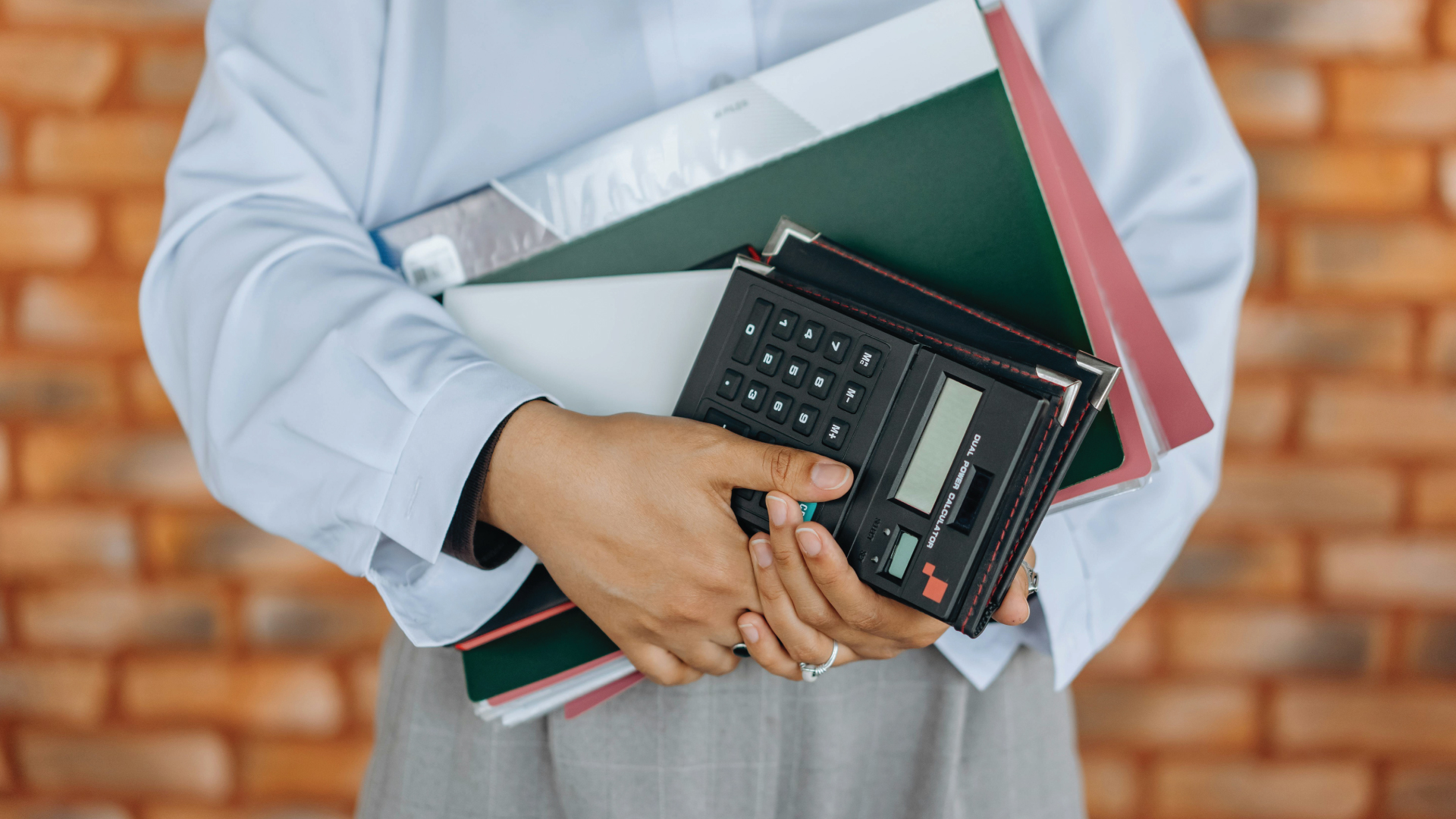 Person holding tax books and calculators.