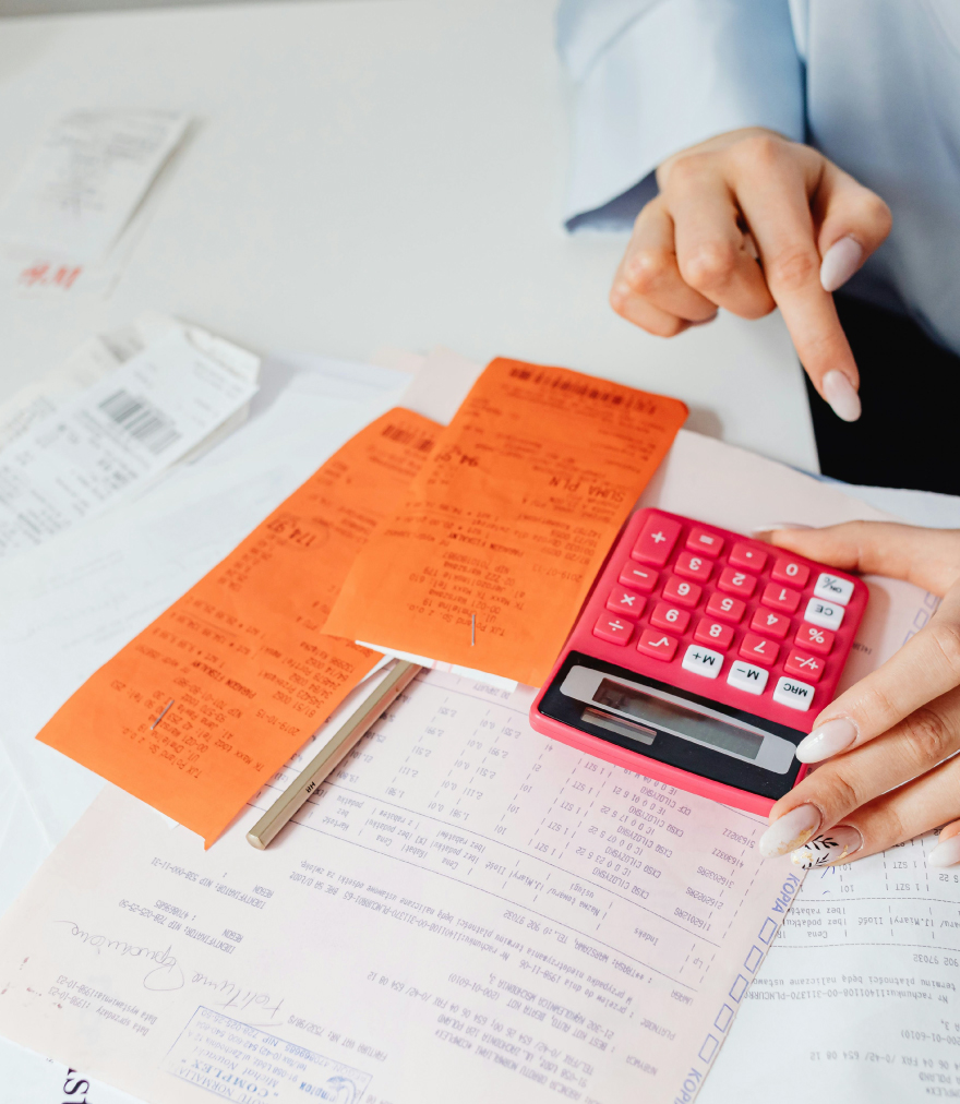 Person doing their business taxes on a calculator.